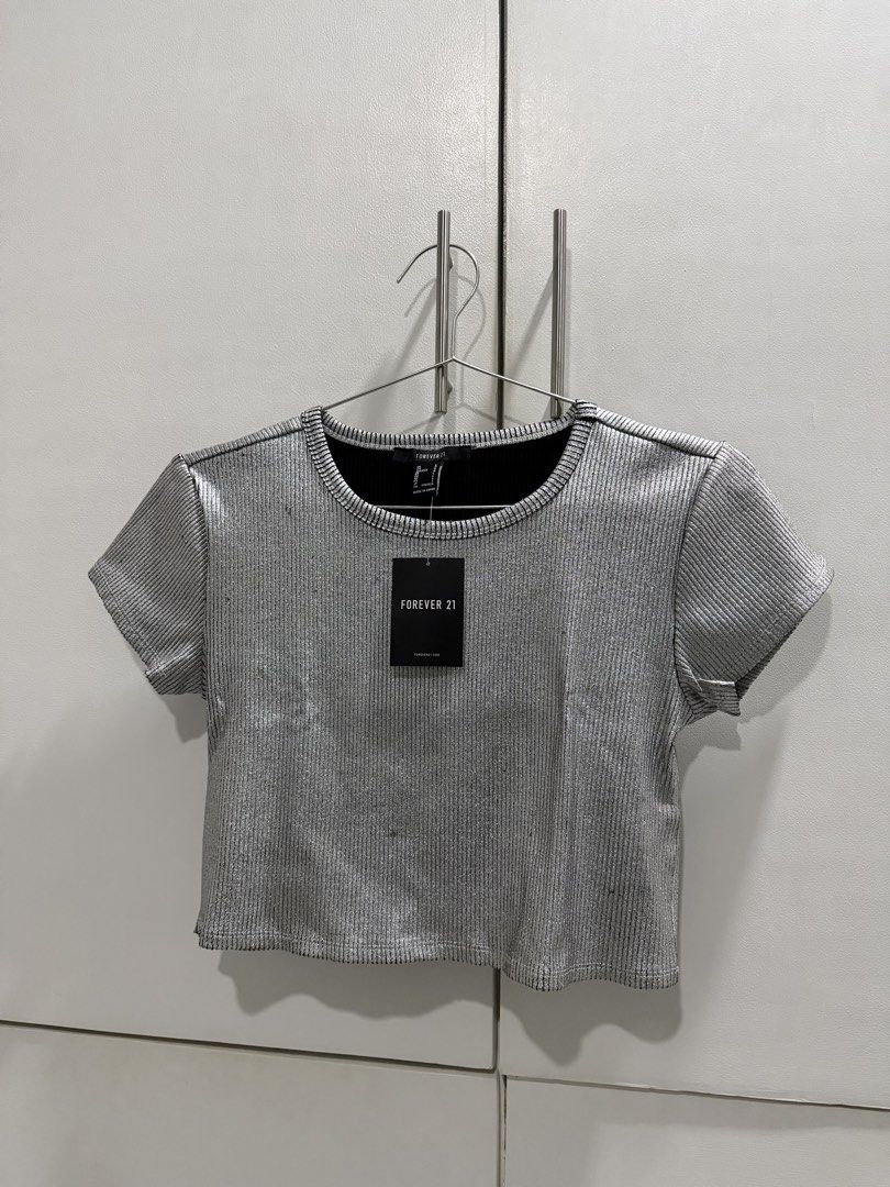 Forever 21 Silver Ribbed Metallic Crop Top (Category: Others Tops) located in Los Banos. Submitted by batmanana (Listing ID 1458863304, Image 2). Description: LAST PRICE POSTED 🥹 buy at least 2 items = FREE SHIPPING ☺️ best fits M-L 10/10 condition, but please still manage your expectations - Forever 21 sparkly silver crop top - Ribbed texture, metallic sheen, short sleeves, crew neck - Ideal for parties or a night out - Brand new with tags stil