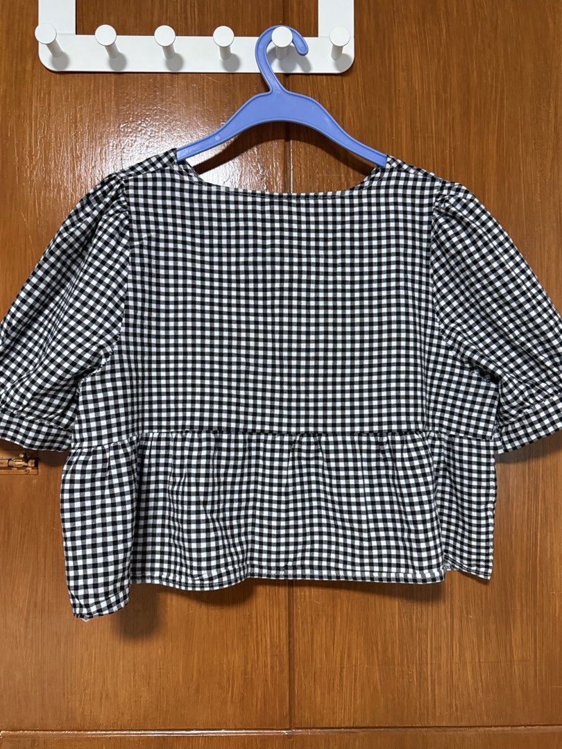 Gingham Top (Category: Blouses) located in San Pedro. Submitted by cutiepagong (Listing ID 1458785452, Image 3). Description: - Classic black and white gingham pattern - Flattering V-neckline with a twist front detail - Trendy puff sleeves - Flared peplum hem for a feminine silhouette - Versatile design for casual or dressed-up looks.