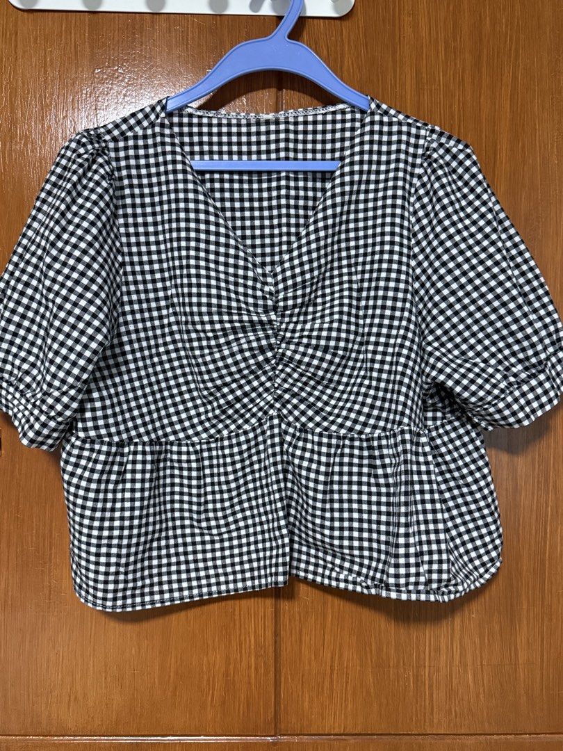 Gingham Top (Category: Blouses) located in San Pedro. Submitted by cutiepagong (Listing ID 1458785452, Image 2). Description: - Classic black and white gingham pattern - Flattering V-neckline with a twist front detail - Trendy puff sleeves - Flared peplum hem for a feminine silhouette - Versatile design for casual or dressed-up looks.