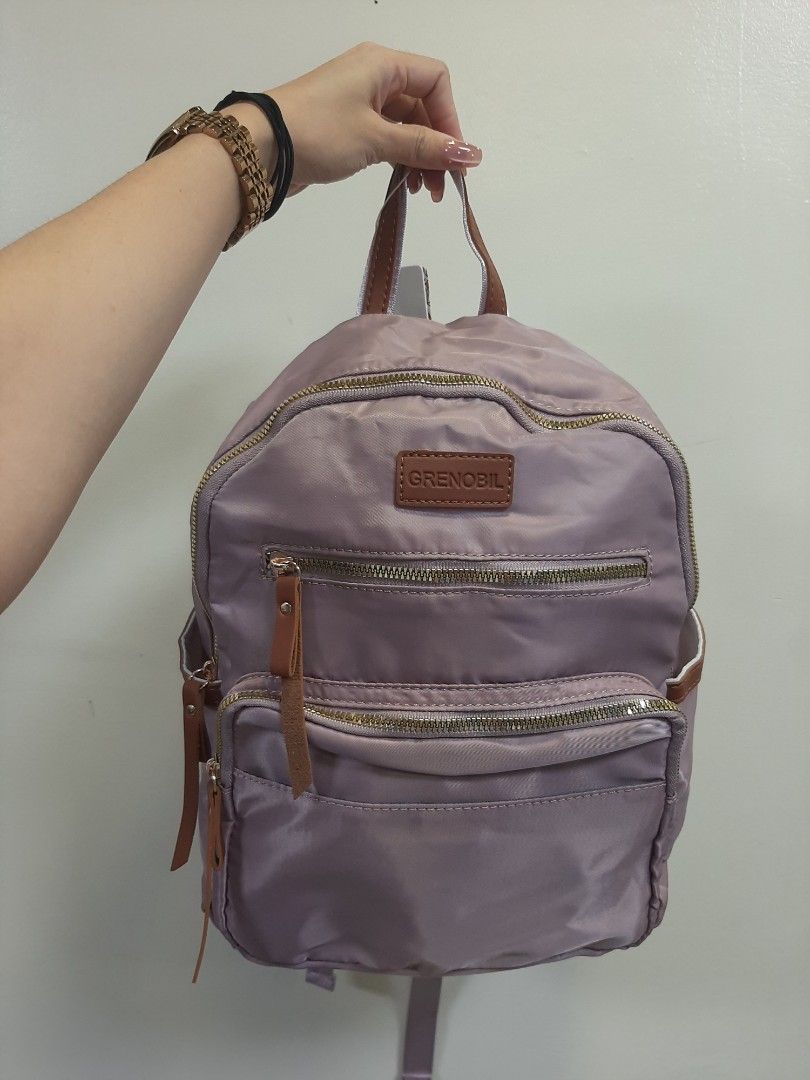 Grenoble Lilac Nylon Backpack with Leather Accents (Category: Backpacks) located in Davao. Submitted by nisa_chan04 (Listing ID 1458693314, Image 2). Description: - Cute lilac backpack from Grenoble - Made with durable nylon - Features stylish leather details on straps and zipper pulls - Multiple zippered pockets on the front for easy access - Adjustable shoulder straps for a comfortable fit - Ideal for everyday use or your next travel adventure.