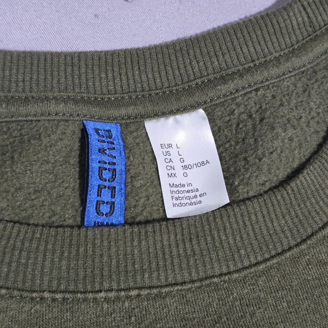 H&M Divided Green Crewneck Sweatshirt (Category: Coats, Jackets and Outerwear) located in Quezon City. Submitted by mfdoooom (Listing ID 1458799633, Image 2). Description: H&M Divided Olive Green Longsleeve Pullover Sweater Size: Large Shoulder - 24" Chest - 25" Length from shoulder tip - 28" Loc: Quezon City & Mandaluyong Delivery: Lalamove/J&T (buyer's expense) Payment: Metrobank/Maribank.