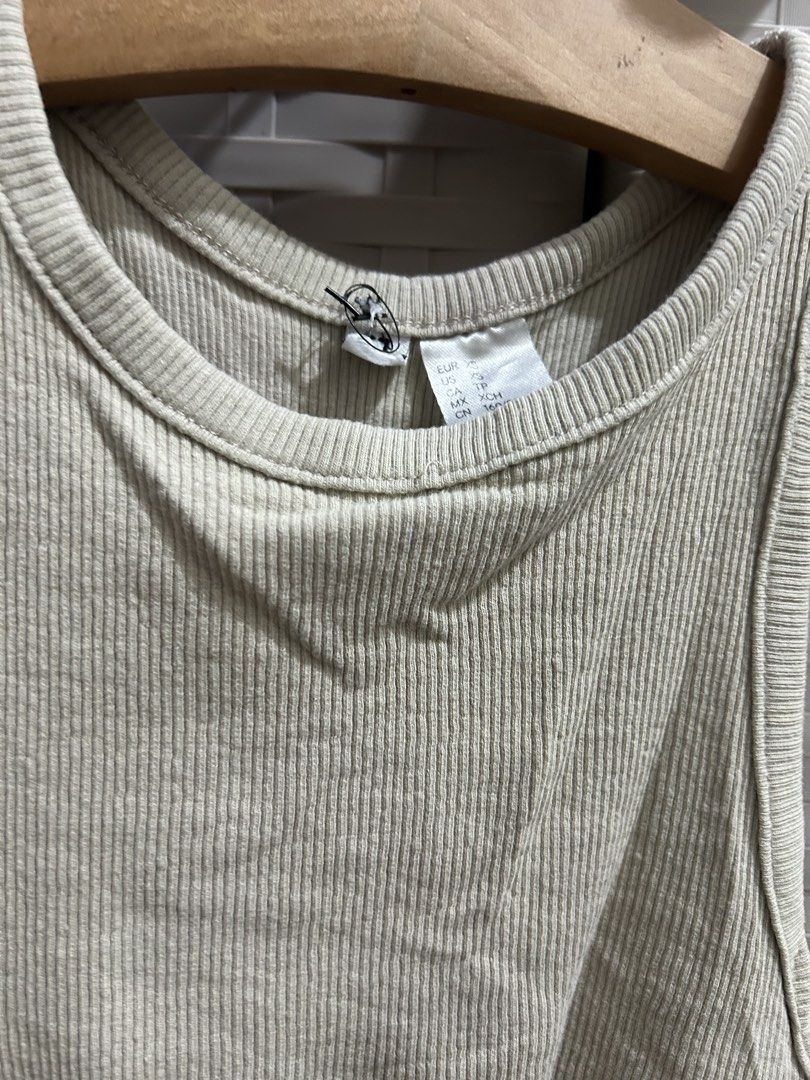 H&M Ribbed Tank Top Beige (Category: Sleeveless) located in San Jose. Submitted by abbsc. (Listing ID 1458690471, Image 2). Description: - Basic ribbed tank top from H&M - Neutral beige color - Racerback style - Stretchy and comfortable material - Versatile for layering or wearing on its own - Easy to pair with any outfit.