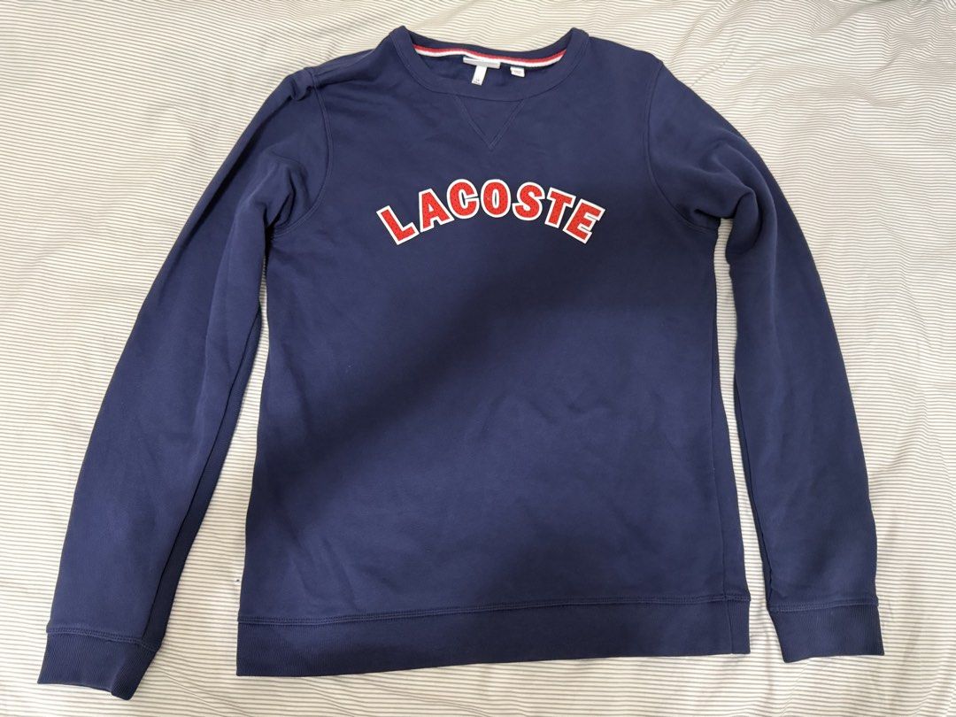 Lacoste Navy Blue Sweatshirt with Red Logo (Category: Longsleeves) located in Makati City. Submitted by meii555 (Listing ID 1458794849, Image 1). Description: - second hand bought from thrift pop up, buy at own risk ! - slightly nego - size 16 - fits me (large-xl) - no pic when worn - measurements on pic - lightly worn - minor issue on logo.