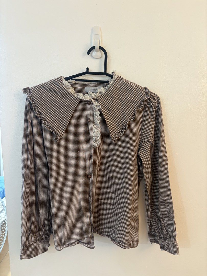 Legato Brown Gingham Peter Pan Collar Blouse (Category: Blouses) located in Navotas City. Submitted by veebernabe (Listing ID 1458730743, Image 1). Description: - Brown gingham blouse - Ruffled Peter Pan collar with lace trim - Button-up front - Long sleeves - Estimated size: Medium - Ideal for vintage or cottagecore aesthetic.