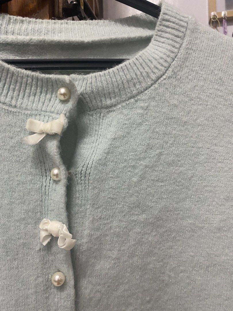 Light Blue Knit Cardigan with Bow Buttons (Category: Coats, Jackets and Outerwear) located in Legazpi City. Submitted by Tfnymae (Listing ID 1458801969, Image 2). Description: - Cute light blue knit cardigan - Features pearl buttons with little white bows - Crew neck, long sleeves - Cozy and sweet style - Ideal for layering over tops or dresses - Easy to button up.