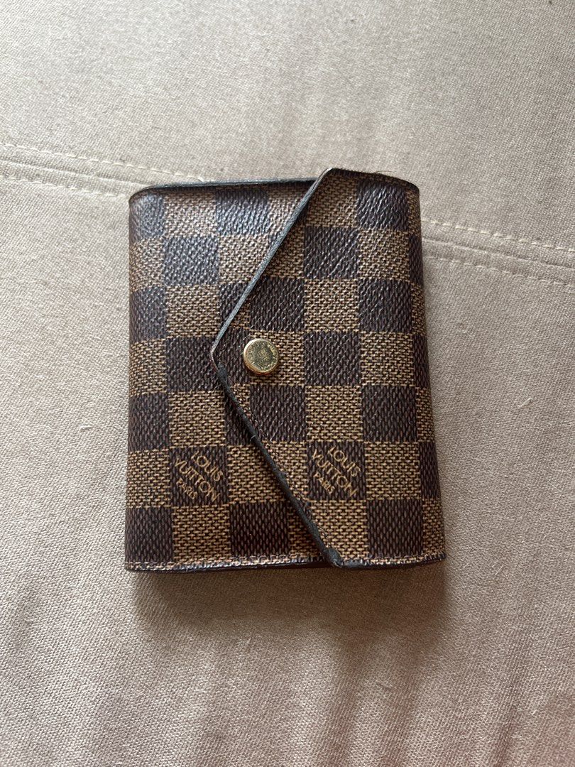 Louis Vuitton Damier Ebene Canvas Tri-fold Wallet (Category: Luxury Bags & Wallets) located in Santa Rosa. Submitted by pepperchill (Listing ID 1458708639, Image 1). Description: - Authentic Louis Vuitton Victorine wallet - Damier Ebene canvas exterior - Red interior - Multiple card slots - Zippered coin pocket - Snap button closure - Classic and essential accessory - 34,500 pa to sa LV website.