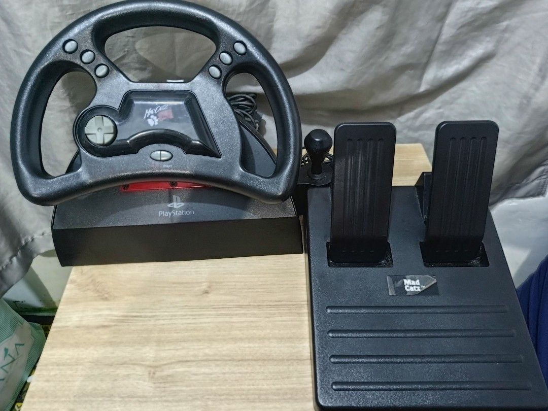 Mad Catz Steering Wheel PS1 (Category: PlayStation) located in Cavite. Submitted by bodega_ni_kiks11 (Listing ID 1458812690, Image 3). Description: Mad Catz Analog & Digital Steering Wheel w/ Foot Pedals for PlayStation PS1 🎮 ✅ Tested & Working ✅ With Original Box ✅ Includes Steering Wheel & Pedals ✅ Great for Retro Gaming & Collectors Condition: Very good working condition. Box has signs of age/storage wear. ₱3,499 Shipping available nationwide