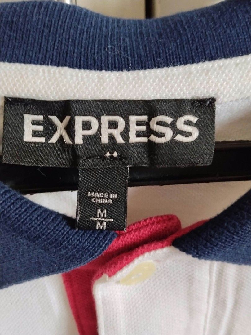 Men's Striped Polo Shirt Size M (Category: Tshirts & Polo Shirts ) located in San Juan City. Submitted by solnbart (Listing ID 1458832449, Image 2). Description: - Express Polo Shirt - Color: White with Navy Stripes - Accent: Red detail under collar - Logo: Small lion emblem on chest - Size: Medium - Ideal for: Casual wear.