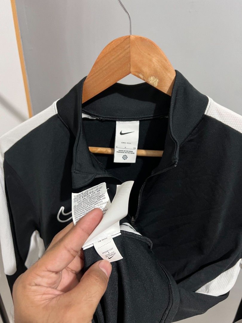 Nike Dri-FIT Black White Track Jacket (Category: Coats, Jackets and Outerwear) located in Manila. Submitted by swifttree-5145 (Listing ID 1458725033, Image 3). Description: - Black and white Nike track jacket - Features a quarter zip closure - Made with Dri-FIT material for sweat-wicking - Comfortable and breathable fabric - Ideal for sports activities or casual everyday wear - Nike logo prominently displayed on the chest.
