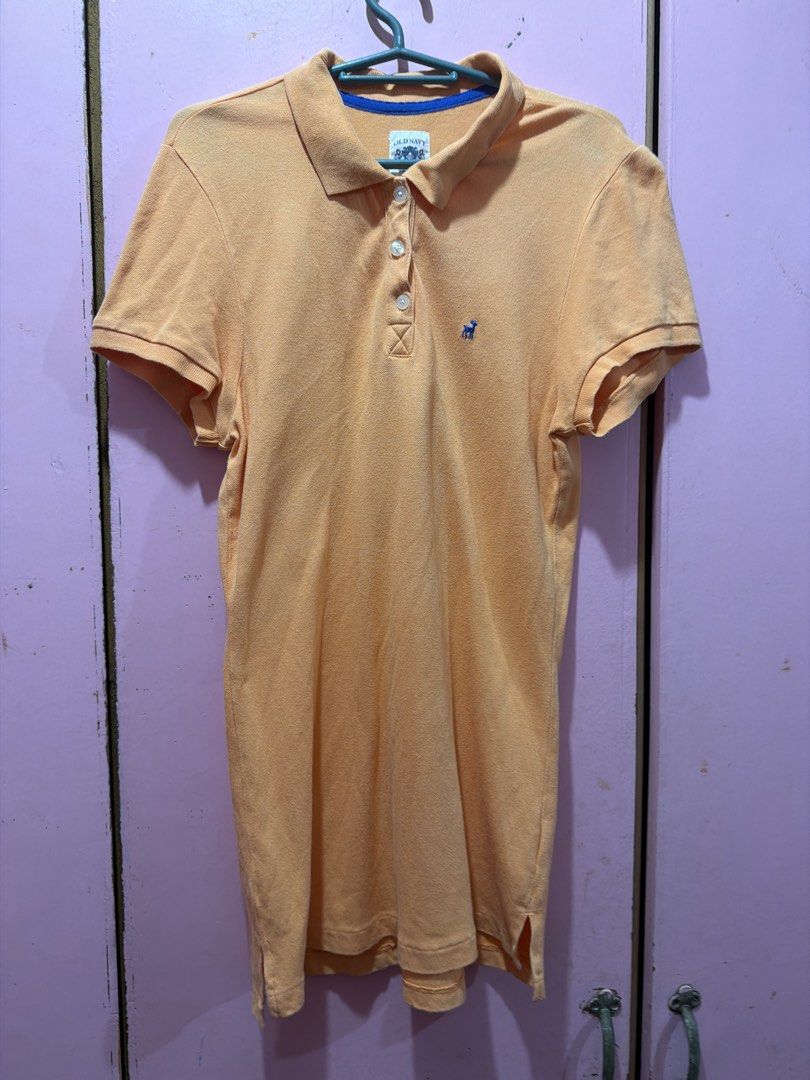 Old Navy Orange Polo Shirt Size M (Category: Shirts) located in Muntinlupa City. Submitted by lybns (Listing ID 1458810552, Image 1). Description: - Orange polo shirt from Old Navy - Size: Medium (M) - Features a small blue embroidered deer logo on the chest - Classic two-button placket - Made in Cambodia - Ideal for casual wear.