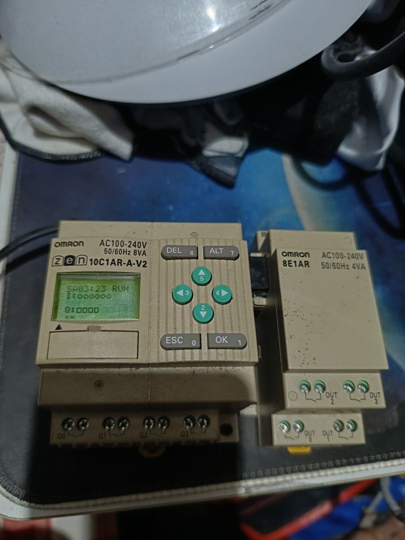 OMRON ZEN 10C1AR-A-V2 Programmable Relay. (Category: Electrical, Adaptors & Sockets) located in Makati City. Submitted by tioli_garage (Listing ID 1458691410, Image 1). Description: - OMRON ZEN 10C1AR-A-V2 Programmable Relay - Includes 8E1AR Expansion Unit - Both units are AC100-240V compatible - Main unit features a small LCD screen and navigation buttons - Expansion unit provides additional output terminals - Ideal for various automation projec