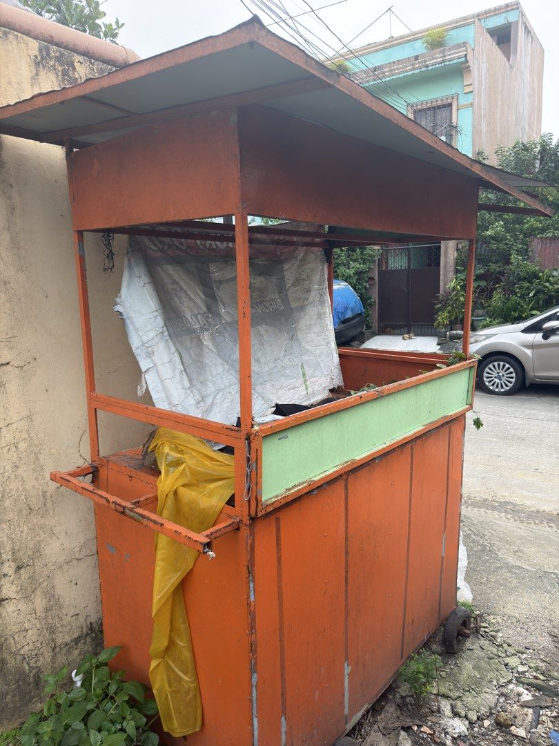 Orange Food Cart with Wheels (Category: Food Organization & Storage) located in Quezon City. Submitted by nathanielstore (Listing ID 1458773875, Image 2). Description: - Orange food cart with green trim - Equipped with wheels for easy mobility - Sturdy metal frame with a roof - Includes attached plastic sheeting - Ideal for starting a small business or street food vending - Ready for your custom setup.