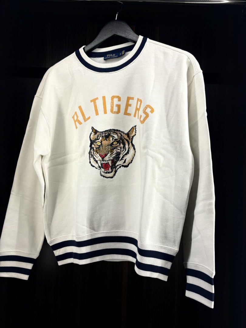 Polo Ralph Lauren RL Tigers Sweatshirt White (Category: Coats, Jackets and Outerwear) located in Angeles City. Submitted by curt_morales (Listing ID 1458828331, Image 1). Description: - Brand: Polo Ralph Lauren - Color: White - Style: Crewneck Sweatshirt - Design: Features the 'RL Tigers' graphic with a tiger face - Details: Striped cuffs and hem - Occasion: Great for casual wear.