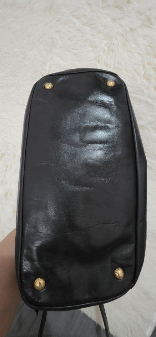 Prada Black Leather Top Handle Bag (Category: Luxury Bags & Wallets) located in Pasig City. Submitted by lfboutique (Listing ID 1458779983, Image 2). Description: pasig loc no cod no damage, professionally recolored minor fade on hardware pls see photos for reference - Authentic black leather Prada handbag - Elegant gold hardware details - Versatile top handle and detachable shoulder strap - Protective studs on the bottom - Shows some signs of we