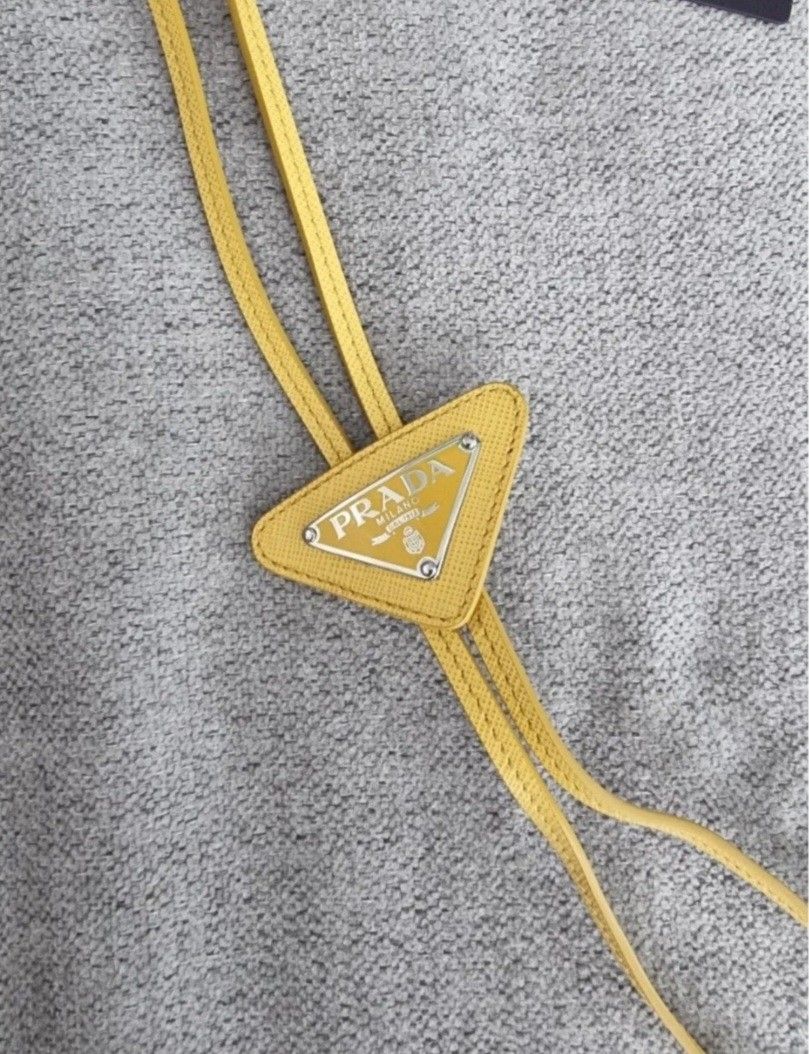 Prada Yellow Leather Triangle Logo Bolo Necktie (Category: Ties) located in Manila. Submitted by jponfashionspeed (Listing ID 1458850817, Image 2). Description: - Authentic Prada bolo leather necktie - Bright yellow leather - Iconic Prada triangle logo - Made in Italy - Comes with original tags - Adds a pop of color to any outfit - Great for gifting or personal use.