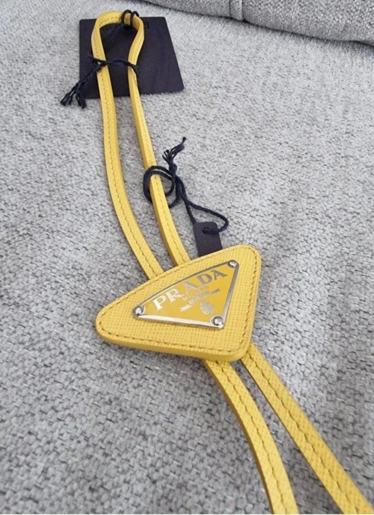Prada Yellow Leather Triangle Logo Bolo Necktie (Category: Ties) located in Manila. Submitted by jponfashionspeed (Listing ID 1458850817, Image 3). Description: - Authentic Prada bolo leather necktie - Bright yellow leather - Iconic Prada triangle logo - Made in Italy - Comes with original tags - Adds a pop of color to any outfit - Great for gifting or personal use.