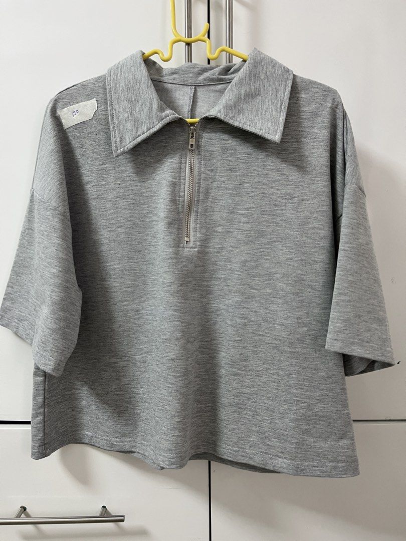 Shein Grey Collared Zip-Up Cropped Top (Category: Blouses) located in Santiago. Submitted by sissy.declutter (Listing ID 1458753264, Image 1). Description: - Length: 20.5 inches, width: 20 inches - Grey cropped top - Collared neckline with silver zipper - Short sleeves - Relaxed fit - Soft and comfortable fabric - Easy to style for casual looks - Pairs well with jeans or shorts.