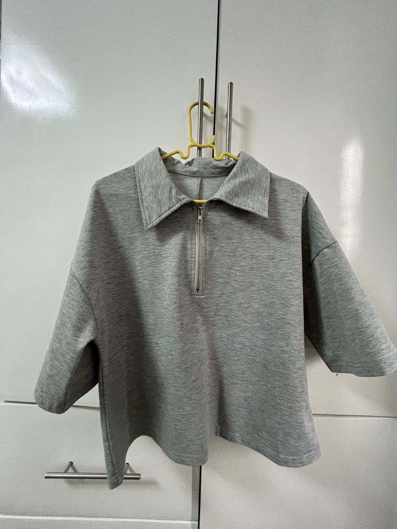 Shein Grey Collared Zip-Up Cropped Top (Category: Blouses) located in Santiago. Submitted by sissy.declutter (Listing ID 1458753264, Image 2). Description: - Length: 20.5 inches, width: 20 inches - Grey cropped top - Collared neckline with silver zipper - Short sleeves - Relaxed fit - Soft and comfortable fabric - Easy to style for casual looks - Pairs well with jeans or shorts.
