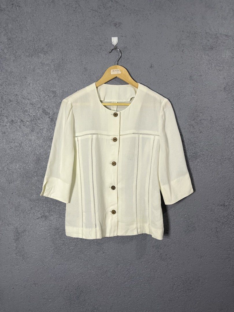 The Pink Tea White Button-Up Blouse (Category: Blouses) located in Famy. Submitted by basicthrifted (Listing ID 1458727477, Image 1). Description: - Brand: The Pink Tea - Color: White - Sleeve Length: Three-quarter sleeves with cuff - Neckline: Simple round neckline - Closure: Wooden-style buttons - Details: Unique textured details on chest and shoulders - Style: Versatile for casual or smart-casual outfits.
