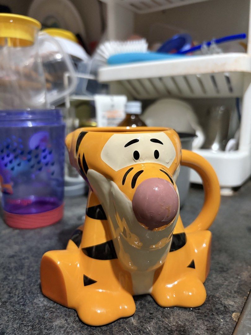 Tigger Shaped Mug (Category: Coffee & Tea Tableware) located in Manila. Submitted by smmcruz (Listing ID 1458854504, Image 1). Description: - Adorable Tigger mug, perfect for coffee or tea. - Shaped like Tigger in a sitting pose. - Features Tigger's signature orange and black stripes and pink nose. - Ideal gift for any Disney or Winnie the Pooh enthusiast. - A fun and unique addition to your kitchenware..