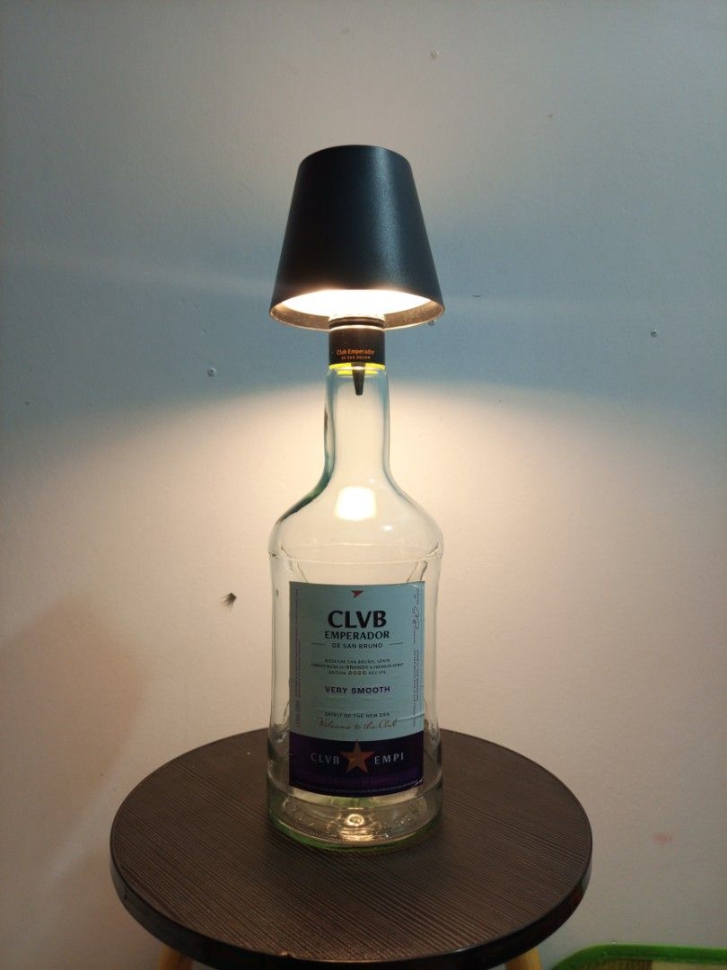 Unique Bottle Table Lamp - Red Horse & Emperador (Category: Lighting) located in Manila. Submitted by warmcrystal_269010 (Listing ID 1458833623, Image 2). Description: - Handcrafted custom table lamps from recycled bottles. - One lamp made from a Red Horse beer bottle. - Second lamp made from an Emperador brandy bottle. - Both lamps feature stylish black lampshades. - Emits a warm, inviting light. - Ideal for man caves, home bars, or unique home 