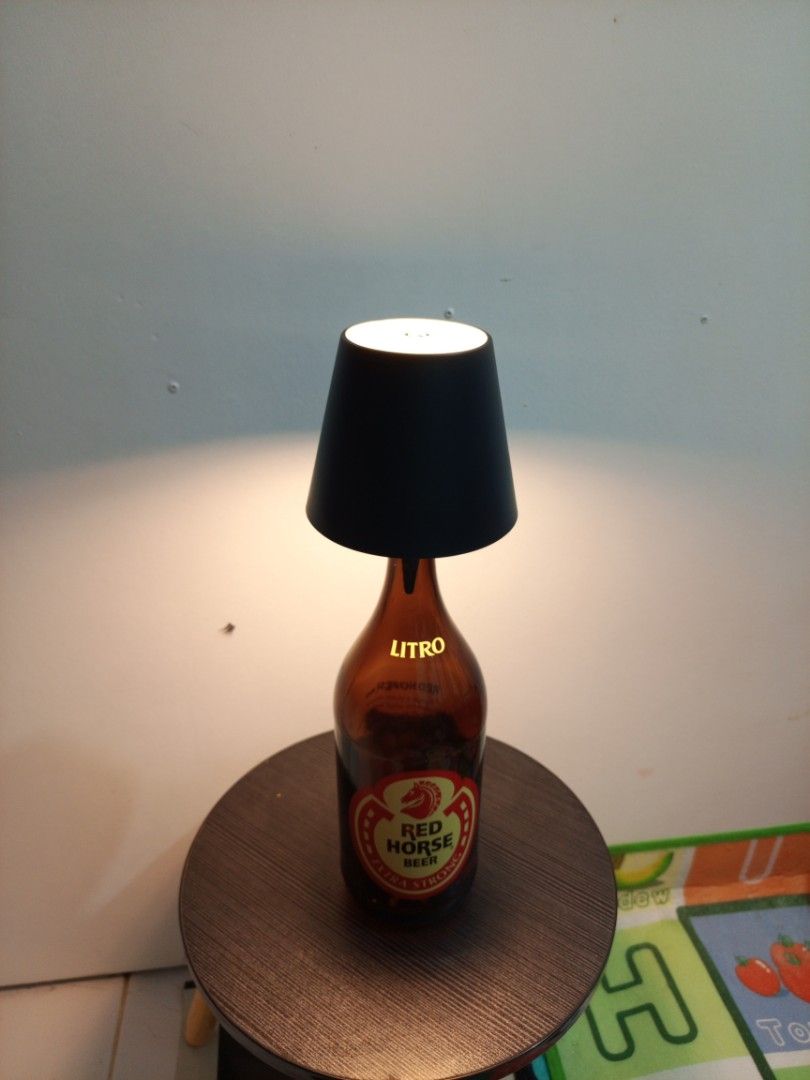 Unique Bottle Table Lamp - Red Horse & Emperador (Category: Lighting) located in Manila. Submitted by warmcrystal_269010 (Listing ID 1458833623, Image 3). Description: - Handcrafted custom table lamps from recycled bottles. - One lamp made from a Red Horse beer bottle. - Second lamp made from an Emperador brandy bottle. - Both lamps feature stylish black lampshades. - Emits a warm, inviting light. - Ideal for man caves, home bars, or unique home 