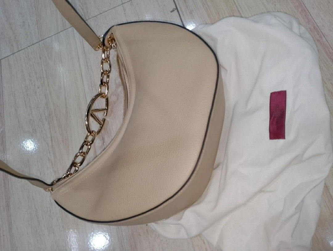 Valentino Garavani V Ring Shoulder Bag (Category: Luxury Bags & Wallets) located in Baguio. Submitted by XycerlynCLXN (Listing ID 1458803732, Image 1). Description: - Valentino Garavani shoulder bag - Color: Beige - Material: Pebbled leather - Hardware: Gold - Signature V ring detail - Interior zip pocket - Includes dust bag - Versatile for everyday or special occasions.