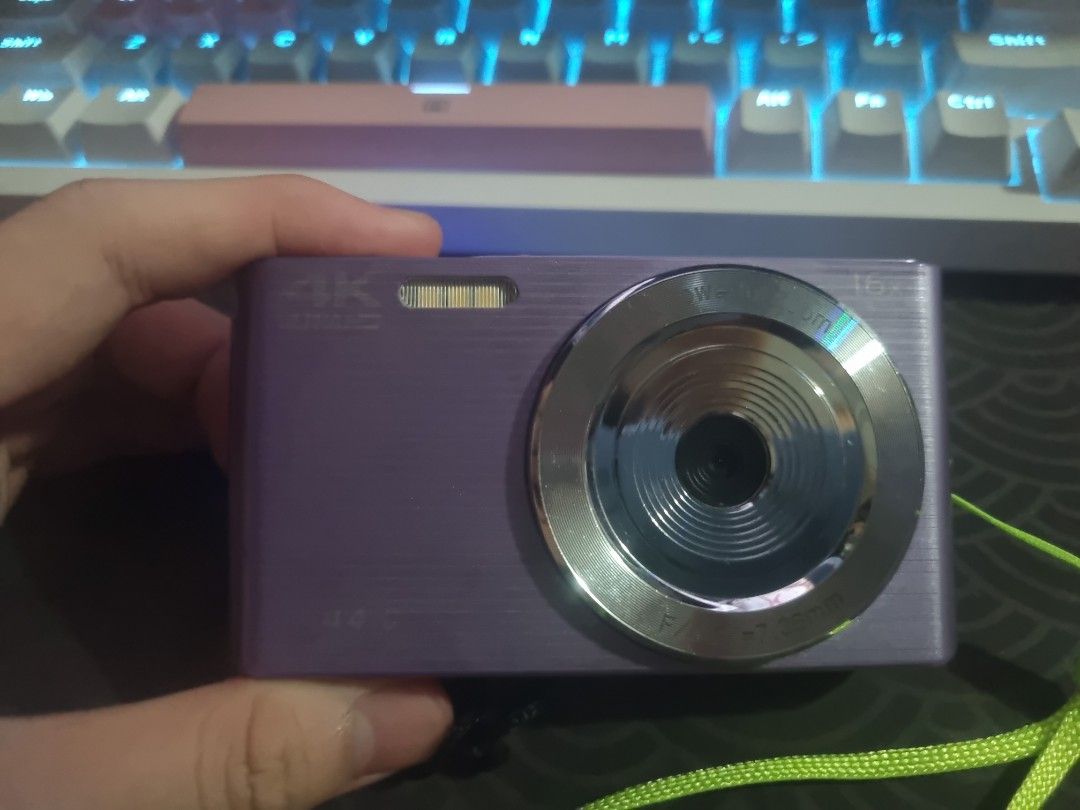 Vetek Digicam (Category: Cameras) located in Manila. Submitted by veejay_ (Listing ID 1458814529, Image 1). Description: - Purple digital camera - Shoots in stunning 4K resolution - Comes with a black protective pouch - Includes a green carrying strap - Screen displays a camera icon - Ideal for casual photos and videos - Lightweight and easy to carry around - 2Months used - Girl Owned -With Issue •Switch Plate [ The one na ginagamit para mag swit