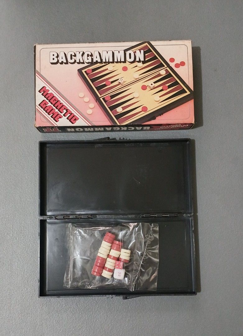 Vintage Magnetic Backgammon Travel Board Game (Category: Board Games & Puzzles) located in Bulacan. Submitted by honhonliz (Listing ID 1458755430, Image 2). Description: This is a complete, vintage pocket-sized magnetic Backgammon game featuring a folding board that doubles as a storage case. The set includes a cream-colored retro cardboard box with red lettering, a hinged black plastic playing board with red and black triangles, a sealed plastic