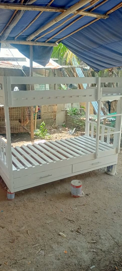 Wooden Bunk Bed with Drawers and Pull-out Beds (Category: Bed Frames & Mattresses) located in Caloocan City. Submitted by newcat-ca23 (Listing ID 1458722105, Image 3). Description: - Solid wood bunk bed - Available in white or dark wood finish - Features two stacked beds with a ladder for access - White bunk bed includes two convenient storage drawers underneath - Excellent space-saving solution - Sturdy and durable construction - Ideal for child