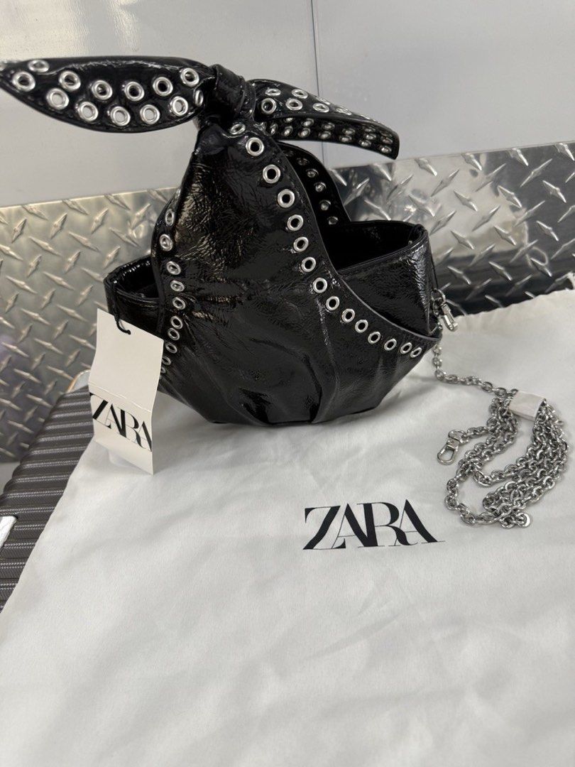 Zara Black Patent Bow Bag with Studs (Category: Luxury Bags & Wallets) located in Calauan. Submitted by lovefelice (Listing ID 1458775305, Image 1). Description: - Zara black patent handbag - Features a cute bow detail with silver studs - Comes with a silver chain strap - Interior zippered pocket - Ideal for night outs or adding an edgy touch to your outfit.