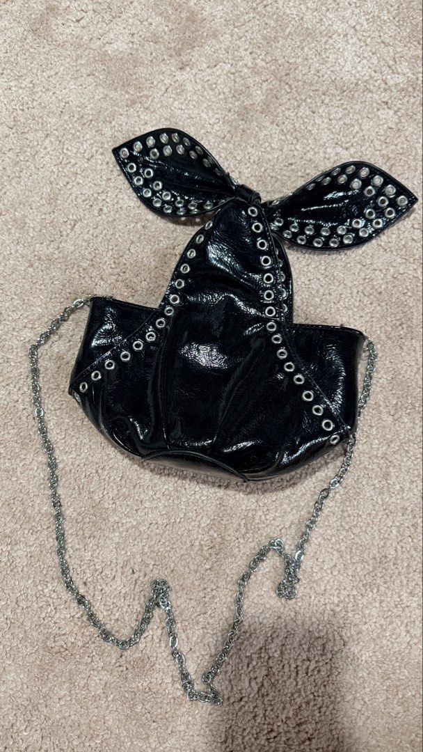 Zara Black Patent Bow Bag with Studs (Category: Luxury Bags & Wallets) located in Calauan. Submitted by lovefelice (Listing ID 1458775305, Image 2). Description: - Zara black patent handbag - Features a cute bow detail with silver studs - Comes with a silver chain strap - Interior zippered pocket - Ideal for night outs or adding an edgy touch to your outfit.