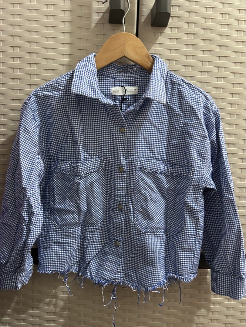 Zara Blue Gingham Cropped Shirt Jacket (Category: Coats, Jackets and Outerwear) located in San Jose. Submitted by abbsc. (Listing ID 1458716321, Image 1). Description: - Zara blue and white gingham shirt jacket - Cropped length with frayed hem - Two chest pockets with button closures - Button-up front - Long sleeves with button cuffs - Versatile for layering or wearing solo - xs-small.