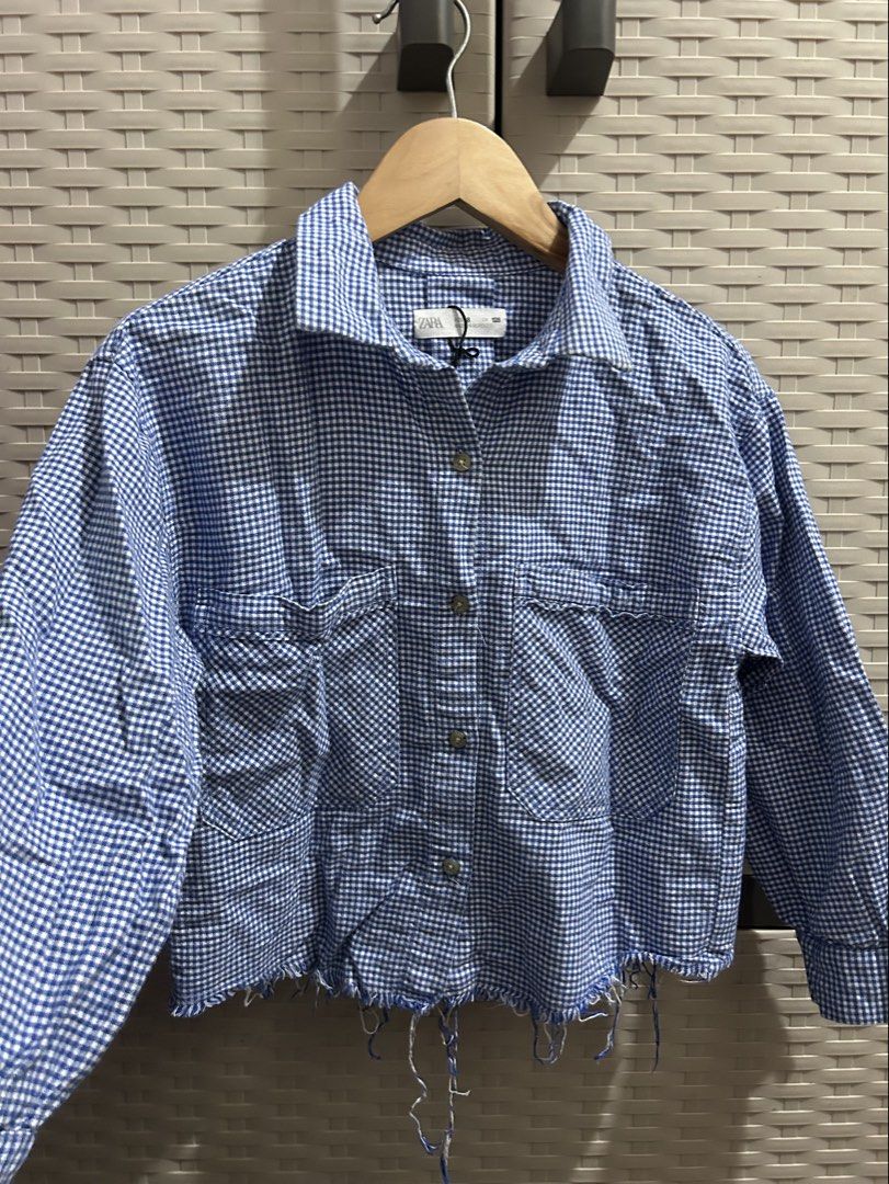 Zara Blue Gingham Cropped Shirt Jacket (Category: Coats, Jackets and Outerwear) located in San Jose. Submitted by abbsc. (Listing ID 1458716321, Image 2). Description: - Zara blue and white gingham shirt jacket - Cropped length with frayed hem - Two chest pockets with button closures - Button-up front - Long sleeves with button cuffs - Versatile for layering or wearing solo - xs-small.