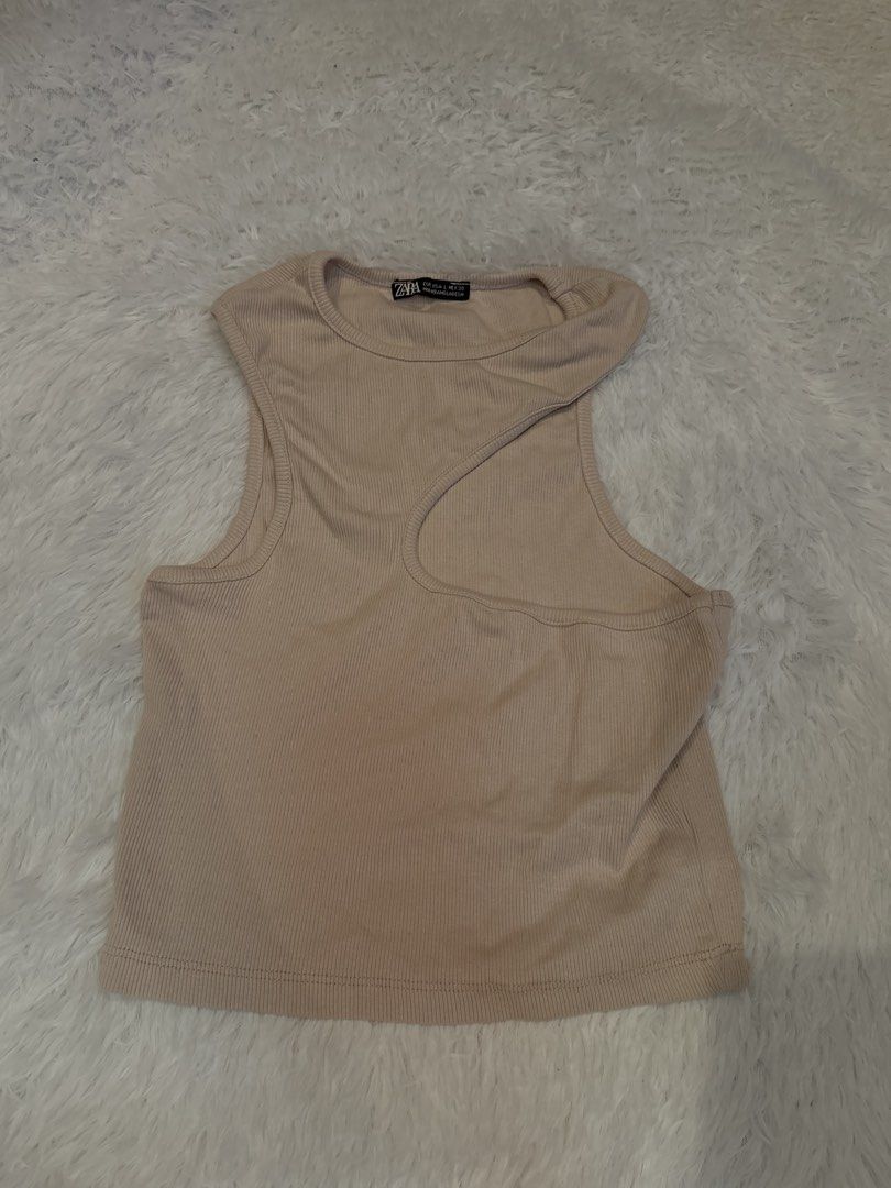 Zara Ribbed Asymmetrical Neck Tank Top (Category: Sleeveless) located in Batangas. Submitted by m4y4rchiv3s (Listing ID 1458808763, Image 1). Description: - Zara ribbed tank top - Chic asymmetrical neckline - Versatile beige/nude color - Comfortable stretchy material - Sleeveless design - Ideal for layering or standalone wear - Matches perfectly with jeans or skirts.