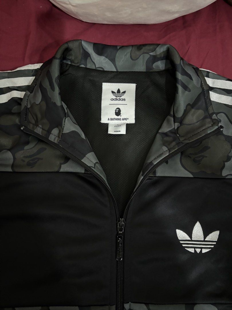 Adidas x A Bathing Ape Camo Track Jacket (Category: Activewear) located in Butuan. Submitted by jnk03 (Listing ID 1453756394, Image 3). Description: - Adidas x A Bathing Ape collaboration - Stylish camouflage pattern - Iconic Adidas 3-Stripes on sleeves - Full zip-up front closure - Convenient front pockets - Versatile for casual wear or athletic activities - Unique and eye-catching design.