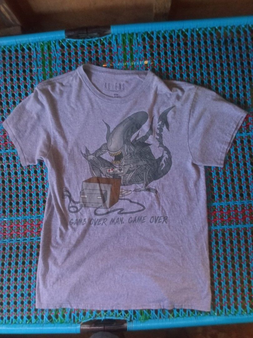 Aliens "Game Over Man" T-Shirt (Category: Tshirts & Polo Shirts ) located in Manila. Submitted by boot_tdm (Listing ID 1453708104, Image 1). Description: - Grey t-shirt with a unique Aliens graphic - Features the Xenomorph playing a video game - Text reads "Game Over Man. Game Over." - Made in Mexico - Size Medium (M).