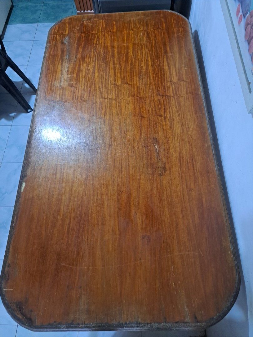 Dining Table (Category: Tables & Sets) located in Quezon City. Submitted by hersheejubilo (Listing ID 1453770587, Image 2). Description: - Rectangular wooden table - Rounded corners with dark edge trim - Visible wood grain - Some marks and wear on the surface - Sturdy construction - Ideal for a workspace or dining area.