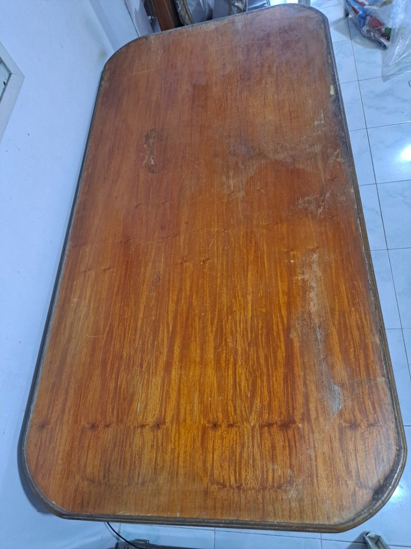 Dining Table (Category: Tables & Sets) located in Quezon City. Submitted by hersheejubilo (Listing ID 1453770587, Image 3). Description: - Rectangular wooden table - Rounded corners with dark edge trim - Visible wood grain - Some marks and wear on the surface - Sturdy construction - Ideal for a workspace or dining area.