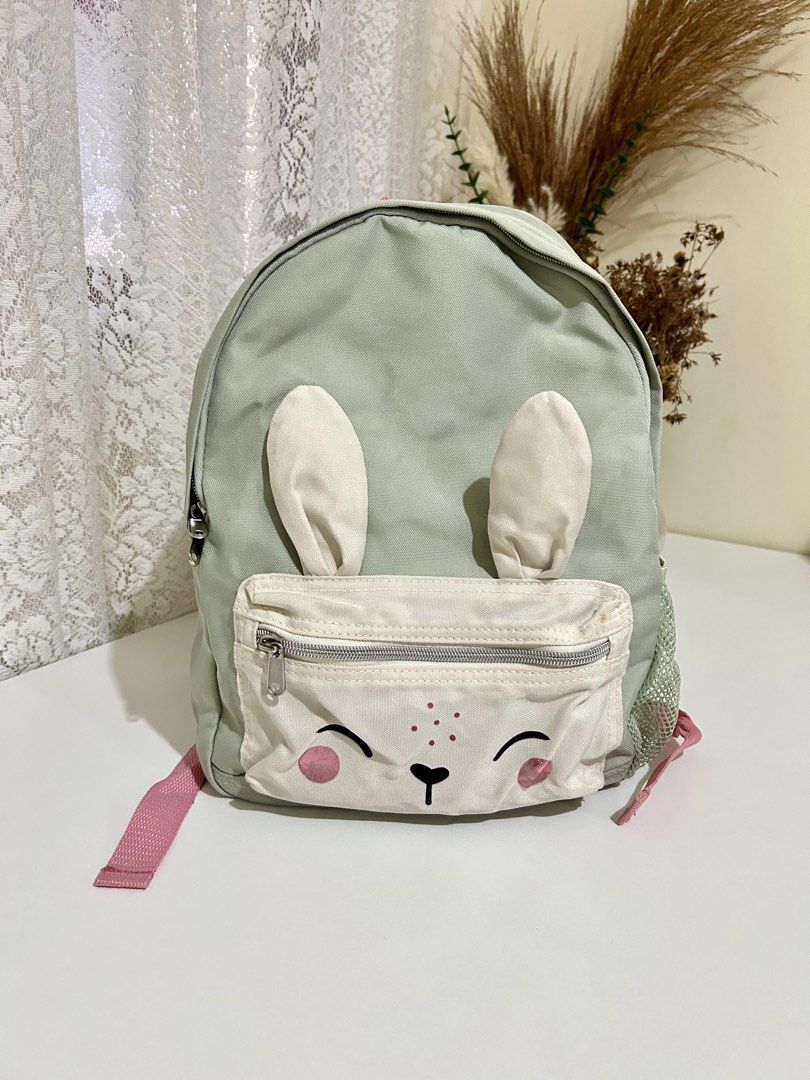 Authentic H&M Bunny Backpack (Category: Babies & Kids Fashion) located in Manila. Submitted by maison_marie (Listing ID 1453772510, Image 1). Description: Sage green backpack with front zip pocket for easy-access essentials. Side mesh pocket for a water bottle. Adjustable shoulder straps. Lightweight and perfect for toddlers or young kids. Condition: There is slight fading on the pink cheek details. Other than that, the bag is in good pre-loved c