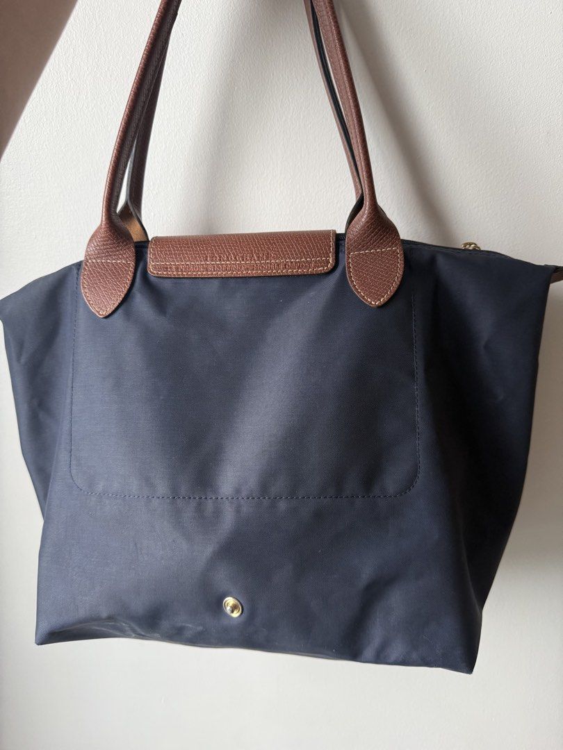 Authentic Longchamp Le Pliage Tote Bag Navy Blue (Category: Luxury Bags & Wallets) located in Manila. Submitted by goldyyyy (Listing ID 1453626051, Image 3). Description: - Classic Longchamp tote bag - Color: Navy blue nylon with brown leather handles and trim - Features: Folds flat for easy storage - Ideal for: Everyday use, travel, carry-on - Closure: Zipper with snap button flap - Interior: Spacious - Style: Reliable and stylish.