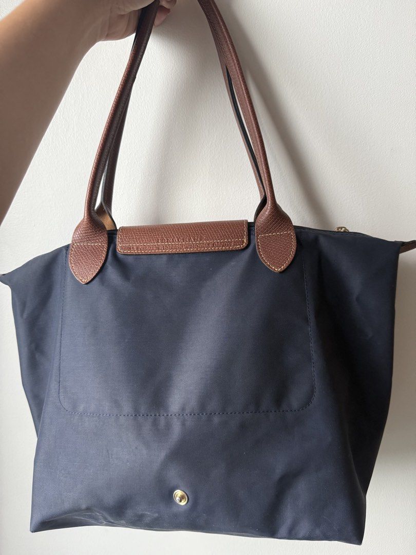 Authentic Longchamp Le Pliage Tote Bag Navy Blue (Category: Luxury Bags & Wallets) located in Manila. Submitted by goldyyyy (Listing ID 1453626051, Image 2). Description: - Classic Longchamp tote bag - Color: Navy blue nylon with brown leather handles and trim - Features: Folds flat for easy storage - Ideal for: Everyday use, travel, carry-on - Closure: Zipper with snap button flap - Interior: Spacious - Style: Reliable and stylish.
