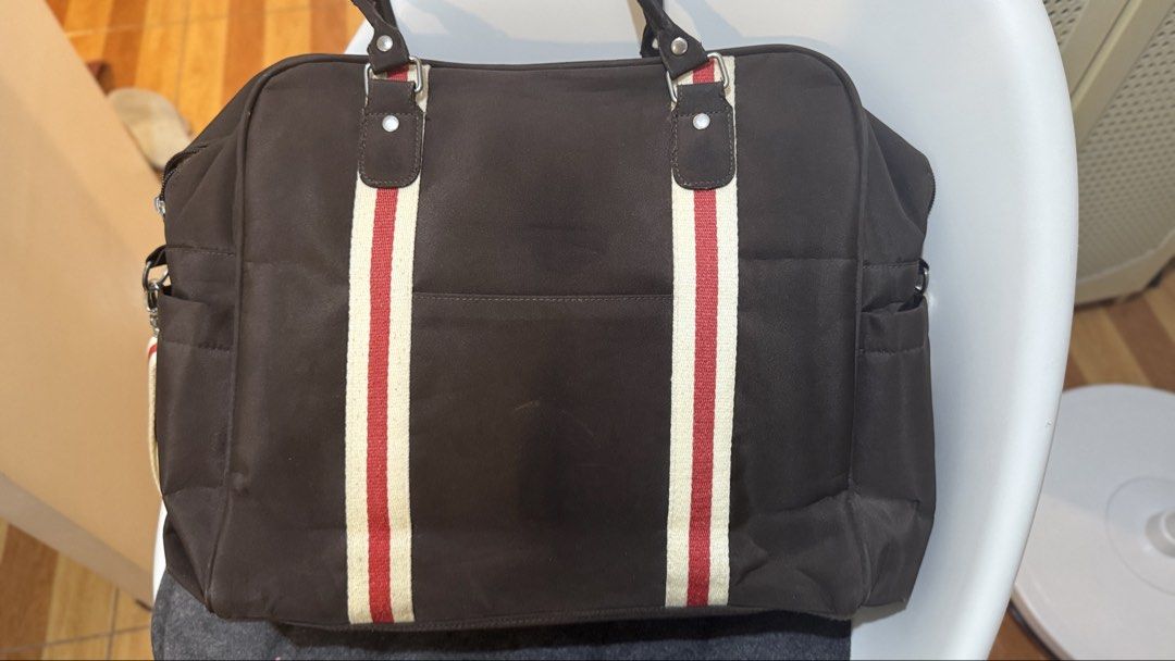 Bebe Chic Diaper Bag - Brown with Red and White Stripes (Category: Diaper Bags & Wetbags) located in San Mateo. Submitted by drewmad (Listing ID 1453787451, Image 3). Description: - Brown Bebe Chic diaper bag - Red and white stripe details on the front - Multiple exterior pockets for easy access - Interior compartments for organized storage - Includes a detachable shoulder strap - Ideal for carrying all your baby's necessities.