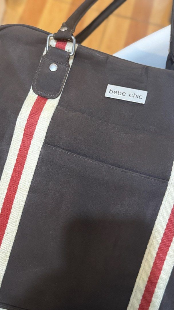 Bebe Chic Diaper Bag - Brown with Red and White Stripes (Category: Diaper Bags & Wetbags) located in San Mateo. Submitted by drewmad (Listing ID 1453787451, Image 2). Description: - Brown Bebe Chic diaper bag - Red and white stripe details on the front - Multiple exterior pockets for easy access - Interior compartments for organized storage - Includes a detachable shoulder strap - Ideal for carrying all your baby's necessities.