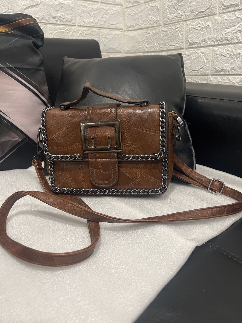 Brown Patchwork Chain Shoulder Bag with Buckle (Category: Shoulder Bags) located in Manila. Submitted by warmturtle_708c3e (Listing ID 1453711462, Image 1). Description: - Stylish cool brown shoulder bag - Unique patchwork design - Chic chain detail along the edges - Secure metal buckle closure on the front - Comes with a long, adjustable strap - Versatile for everyday wear or evening outings - three- way bag handbag/ shoulder/ buddy bag.