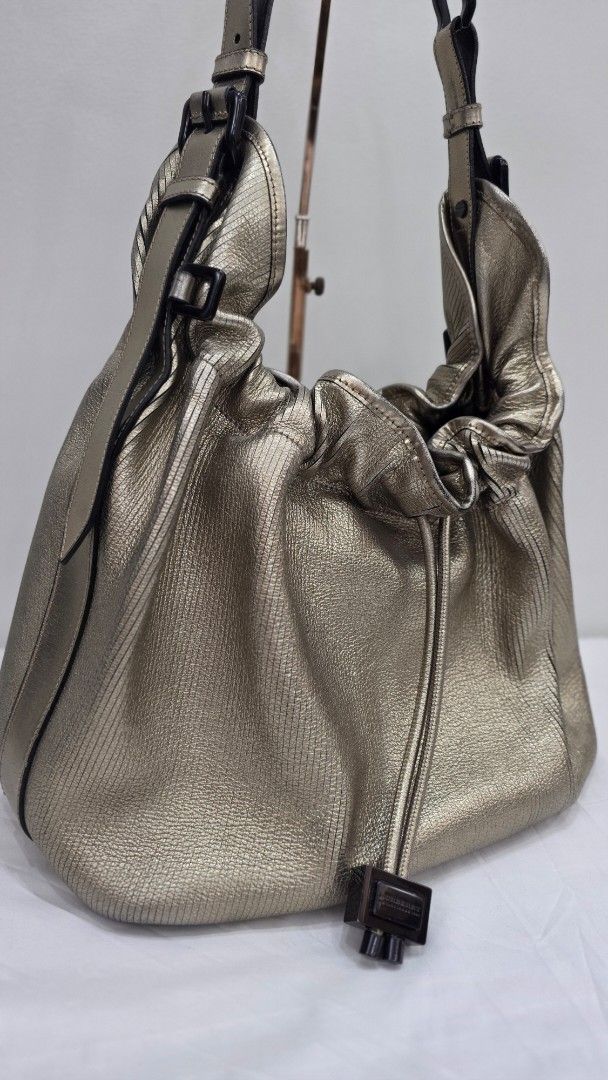 Burberry Metallic Leather Drawstring Hobo Bag (Category: Luxury Bags & Wallets) located in San Fernando. Submitted by bagproject (Listing ID 1453699818, Image 2). Description: - Stunning metallic gold finish - Made from soft, textured leather - Secure drawstring closure with stylish toggle - Good condition.