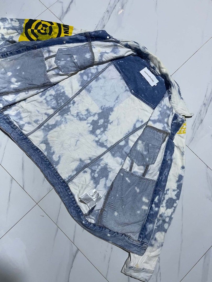Calvin Klein Jeans Bleached Patchwork Denim Jacket (Category: Coats, Jackets and Outerwear) located in Pangantucan. Submitted by calmwhale_cb83a8 (Listing ID 1453694844, Image 2). Description: - Cool Calvin Klein Jeans denim jacket - Size: L - Unique bleached wash - Patchwork details -excellent condition need wash - Graphic prints on front and back - Perfect statement piece for your wardrobe.