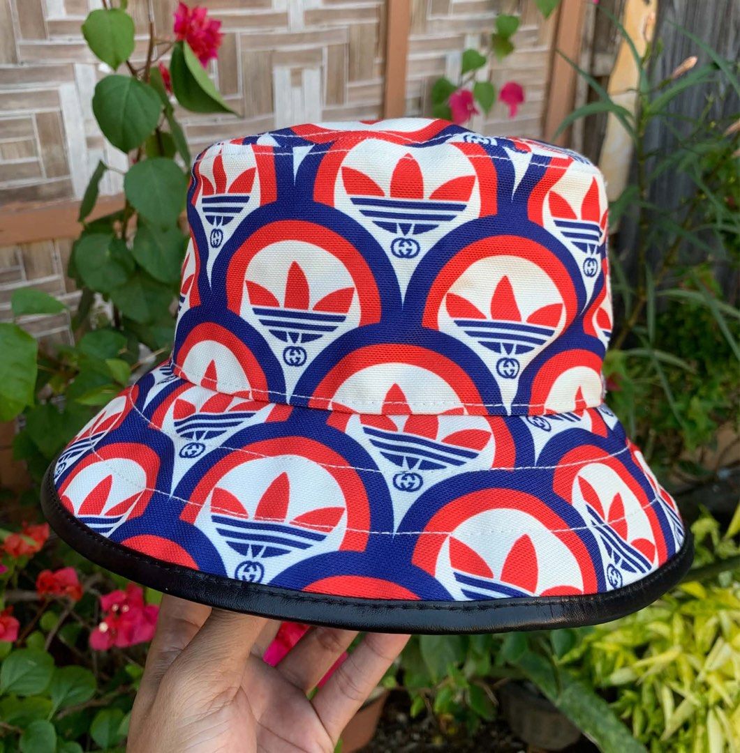 Gucci x Adidas Bucket Hat (Category: Caps & Hats) located in Tagum. Submitted by knilevinc69480 (Listing ID 1453715291, Image 2). Description: - Authentic Gucci x Adidas collaboration bucket hat - Features iconic GG monogram and Adidas trefoil logo pattern - Made in Italy - Neutral beige interior lining - A statement piece for any streetwear outfit - Please check photos for detailed condition - Size Medium to Large.