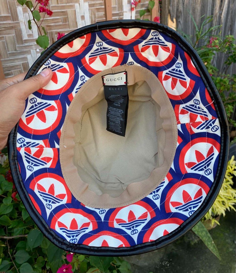Gucci x Adidas Bucket Hat (Category: Caps & Hats) located in Tagum. Submitted by knilevinc69480 (Listing ID 1453715291, Image 1). Description: - Authentic Gucci x Adidas collaboration bucket hat - Features iconic GG monogram and Adidas trefoil logo pattern - Made in Italy - Neutral beige interior lining - A statement piece for any streetwear outfit - Please check photos for detailed condition - Size Medium to Large.