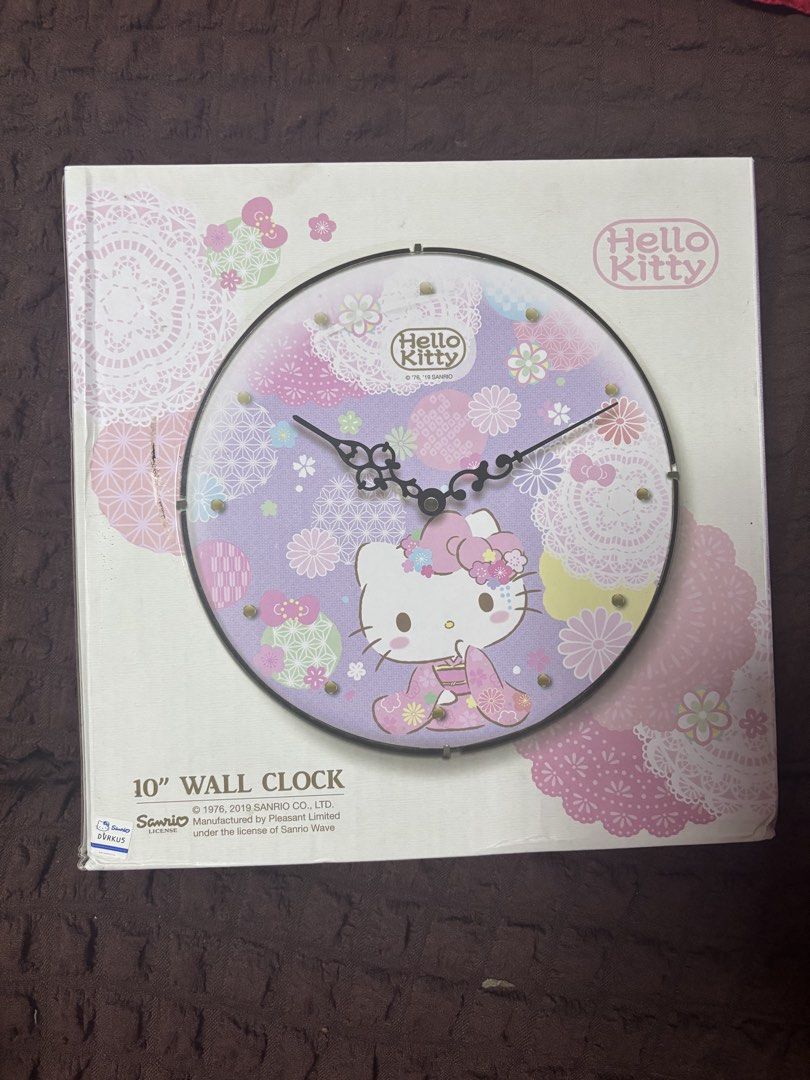 Hello Kitty 10" Wall Clock - Sanrio Licensed (Category: Clocks) located in Quezon City. Submitted by jaedenry0228 (Listing ID 1453631204, Image 1). Description: - Adorable 10-inch Kitty wall clock. - Features a charming purple background with floral and lace details. - Kitty is depicted in a traditional kimono. - Ideal for any Kitty enthusiast's room or as a thoughtful gift. - Requires 1 AA battery (not included). - Manufactured under license by 